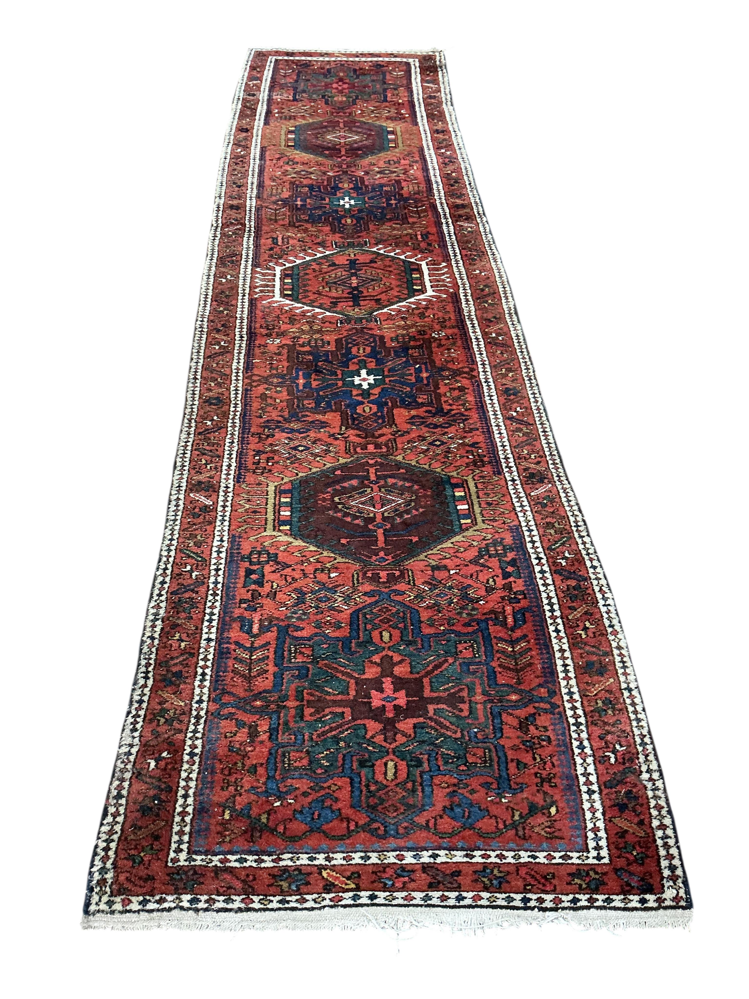 A Karaja runner, the red field with six medallions, 335 x 82cm